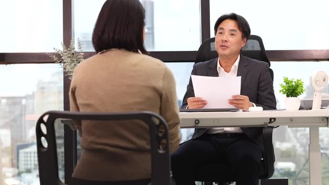 Asian Businessman Conducting Job Interview with Candidate in Modern Office