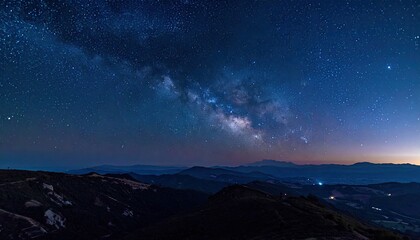 Milky Way shines over dark hills, a cosmic panorama