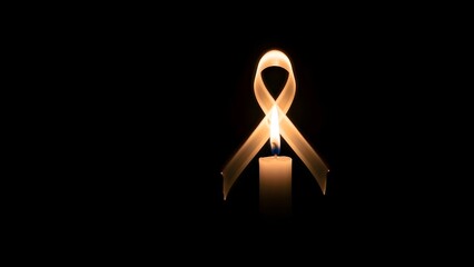 Golden Awareness Ribbon Candle on Dark Background, Cancer Support and Memorial Symbol