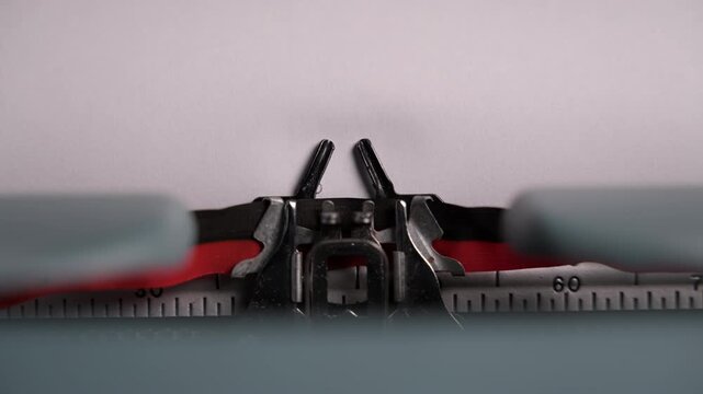 Close-up of a vintage typewriter mechanism printing the words to be continued on paper. Moving metal parts and classic design create a nostalgic retro writing atmosphere.