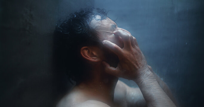Mental health, angry and man in shower with reflection, anxiety trigger or memory of past trauma. Grief, flashback and male person in bathroom with sadness, regret or fatigue in emotional thoughts.