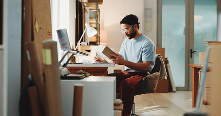Ecommerce, man and writing in office with box for customer order, shipping inspection or verification. Person, reading package or notes in workplace for logistics, quality control or courier service. © BuyOutFelix06/peopleimages.com