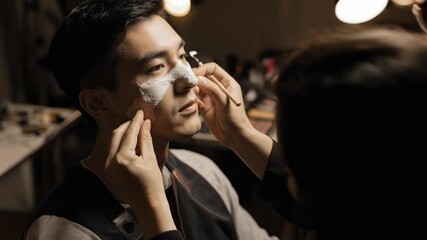 Man receives cosmetic treatment on his face in a salon