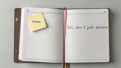 Open notebook with motivational quote and sticky note highlighting values for personal growth and reflection in workspace
