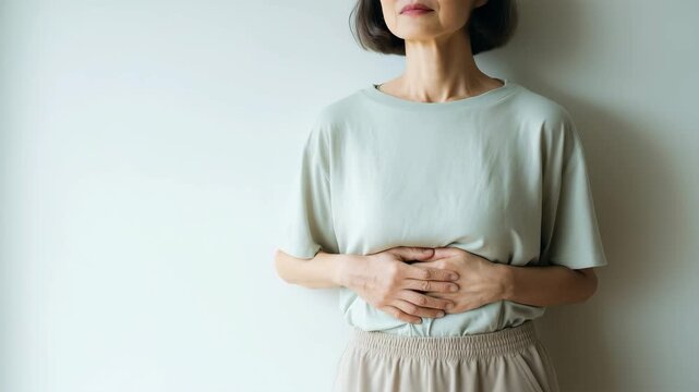 腹部を両手でつまみ健康意識を示す女性の体型チェック