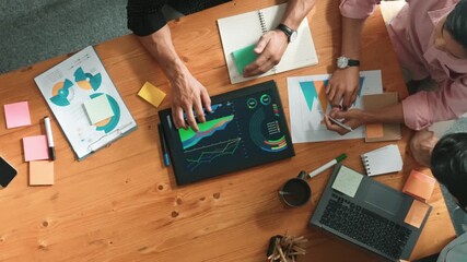Top view of skilled project manager talking about financial graph to investors while sitting at meeting table with data analysis document. Diverse team discussing and brainstorming idea. Convocation. - Powered by Adobe