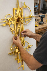 Crafting geometric brass wall sculpture in workshop