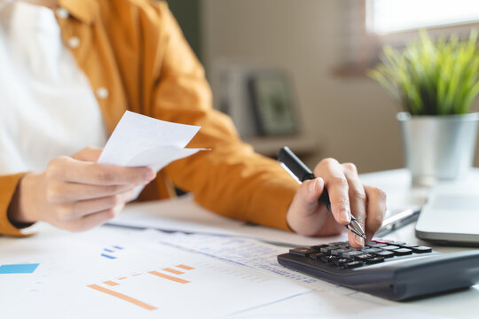 person using calculator calculating tax refund on the table