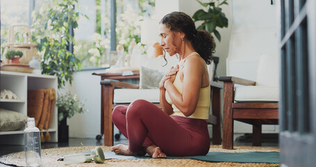 Mindfulness, calm and woman on yoga mat in home, awareness practice and grounding exercise for...