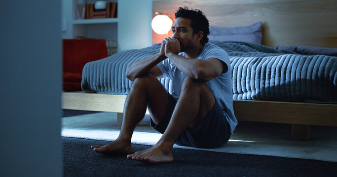 Night, anxiety and man with depression, mental health and insomnia from sad thoughts in bedroom. Late, contemplation and anxious person with grief, worry and sleepless from stress in apartment.