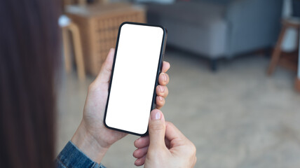 Mockup, blank screen cell phone. Woman hand holding, using mobile phone at cafe with white empty space for advertise text. contact business, social meida communication, technology device, closeup