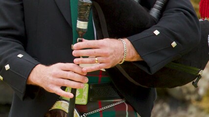 Close Up of Hands Playing Bagpipes in Traditional Scottish Attire