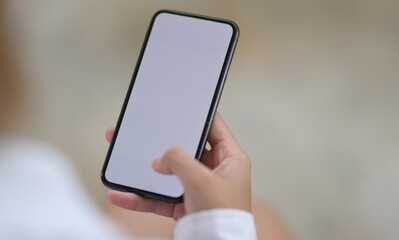Person holding a smartphone with a blank screen in their hand