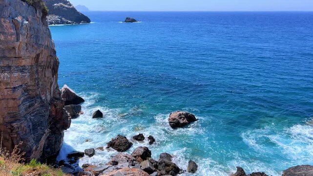 The rocky coast of the Mediterranean Sea near Gazipasa, with crystal-clear water in Turkey. Rocky cliffs and a bright turquoise sea. A sea dotted with rocks. Waves crashing against the rocky shore. 4К