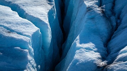 Close-up view of deep crevasses in a glacier with blue ice formations