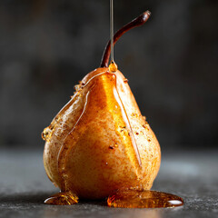 A pear is being drizzled with a sweet syrup or honey slowly