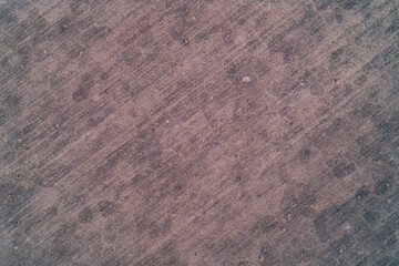 Uneven ground texture with dug holes and dry grass patterns in rural field aerial top down view