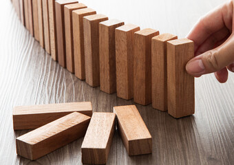 Hand stopping domino effect preventing risk management