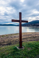 Wooden cross on the lake shore