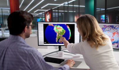 Female Meteorologist Tracks Climate Data On Office Computer Screen