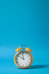 Minimalist Orange Alarm Clock On Blue Background Representing Time Management
