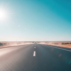 Fototapeta premium Asphalt highway stretching to horizon under a bright sun, flanked by dry fields
