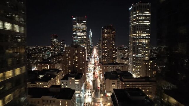 Cinematic aerial night view of San Francisco downtown skyline featuring the Salesforce Tower and illuminated city streets with traffic lights.
