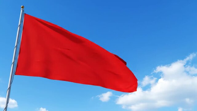 Red flag flying against blue sky with clouds symbol of warning