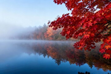 Autumn landscape with red maple leaves and misty lake reflection