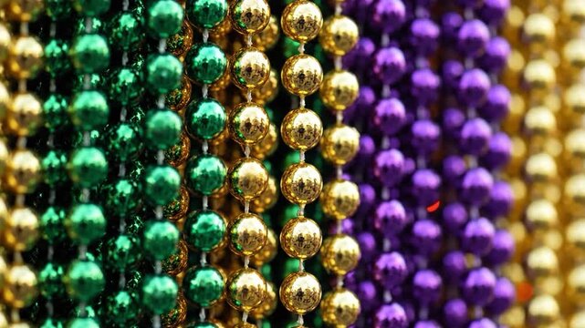 Colorful beads in green, gold, and purple hues, densely packed