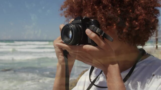 Animation of tree over african american woman taking photo