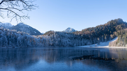 Frosty Mountains mirroring in the Alatsee in Bavaria Allgaeu Germany with great sunny Winter Vibes....