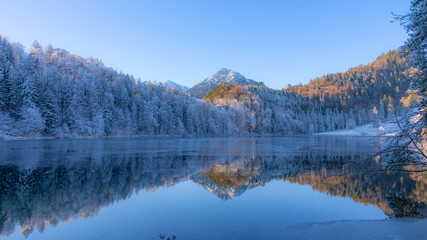 Frosty Mountains mirroring in the Alatsee in Bavaria Allgaeu Germany with great sunny Winter Vibes....