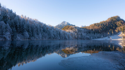 Frosty Mountains mirroring in the Alatsee in Bavaria Allgaeu Germany with great sunny Winter Vibes....