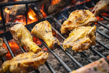 Grilling chicken pieces on barbecue during outdoor cooking event