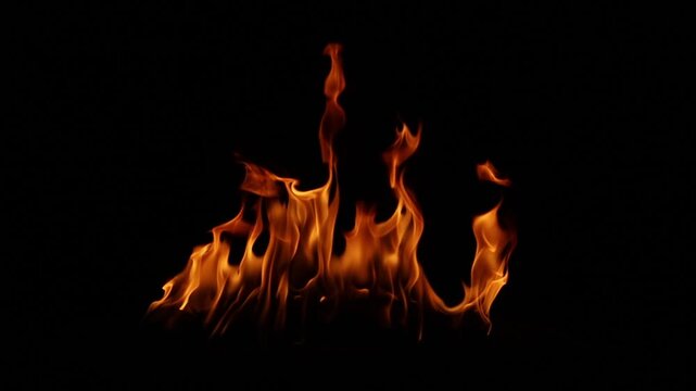 Fire flames burning in the dark night with black background. Abstract flame pattern symbolizing danger, heat, energy, power, passion, and dramatic atmosphere for design and advertising use.