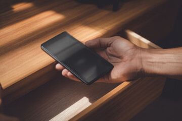 Digital detox concept with smartphone locked away in drawer sunlight streaming across wooden surface calm atmosphere promoting mindful technology use and relaxation