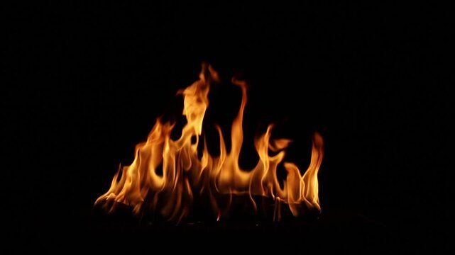 Fire flames burning in the dark night with black background. Abstract flame pattern symbolizing danger, heat, energy, power, passion, and dramatic atmosphere for design and advertising use.