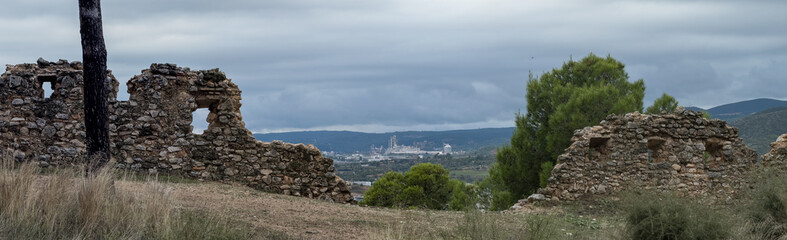 Ancient Stone Ruins Overlooking Modern Industrial Landscape