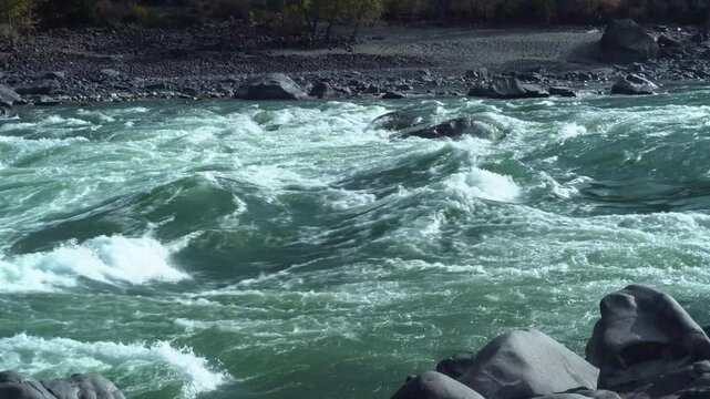 Green River Rapids Crashing Over Rocks With Frothy Foam And Fast Current, Rugged Boulders Lining Shore, Emerald Water Churn, WindWhipped Spray, Dramatic Mountain Setting Ideal For Nature Study