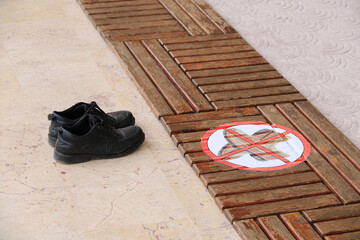 ein Paar schwarze Schuhe stehen im Eingangsbereich einer Moschee - Eintritt mit Schuhen verboten
