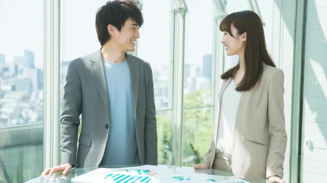 若手同士で契約の握手を交わす男女のビジネス場面