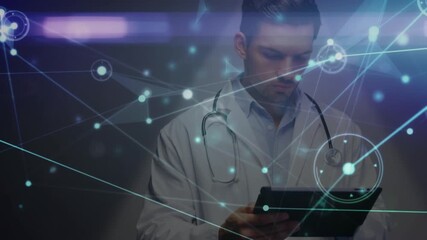 Animation of glowing network of connections over caucasian male doctor using digital tablet