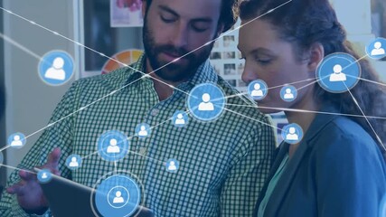 Animation of connected icons over diverse coworkers discussing reports on digital tablet in office - Powered by Adobe