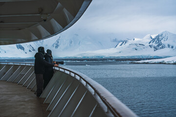 Antarctica Man Woman in Love Stand Together on Deck Looking at Frozen Landscape Glaciers Snow Covered Mountains. Adventure Travel Couple Goals Remote © And They Travel