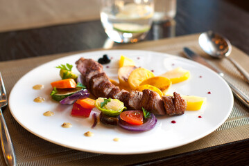 Plate with grilled meat (pork loin) and vegetables in restaurant