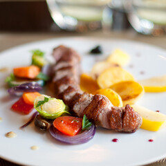 Plate with grilled meat (pork loin) and vegetables in restaurant