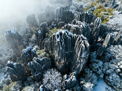 Aerial view of snow-covered rock formations in a misty mountain landscape - Powered by Adobe