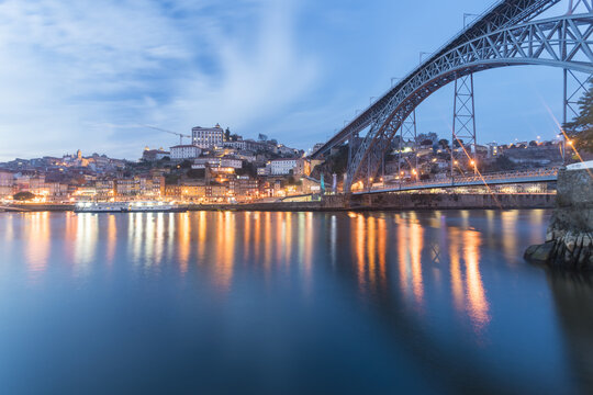 View of the Dom Lu&Atilde;&shy;s I Bridge stretches gracefully across the tranquil Douro River, reflecting the city lights in Porto, Porto District, Portugal.