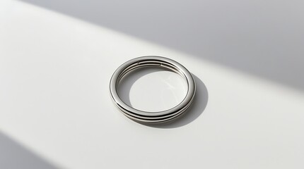 A single stainless steel key ring, minimal design, placed flat on a white surface, isolated on pure white background, soft studio lighting, subtle shadow, ultra-realistic product photography.